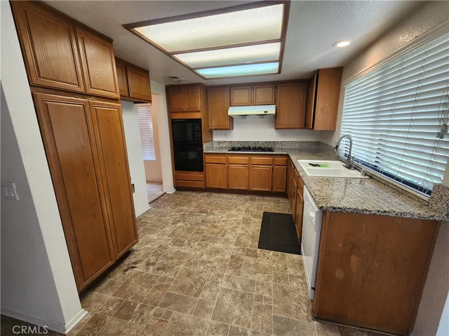 a kitchen with stainless steel appliances granite countertop a refrigerator and a stove