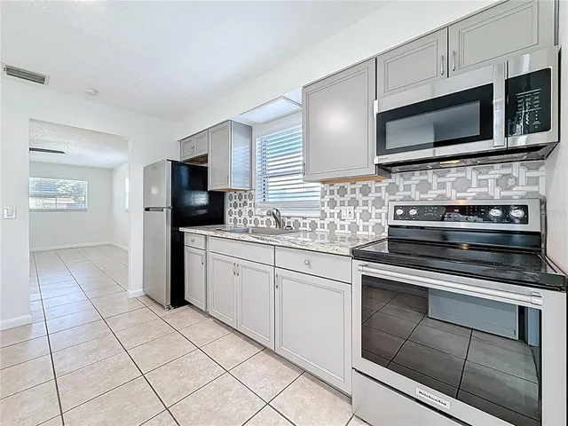 a kitchen with granite countertop a sink and steel stainless steel appliances