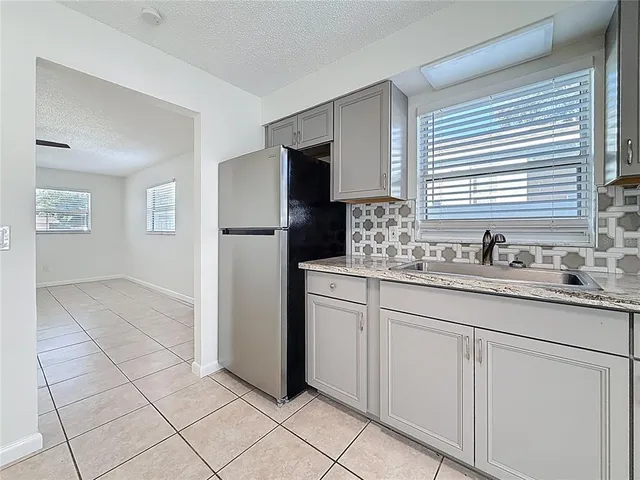 a kitchen with sink and refrigerator