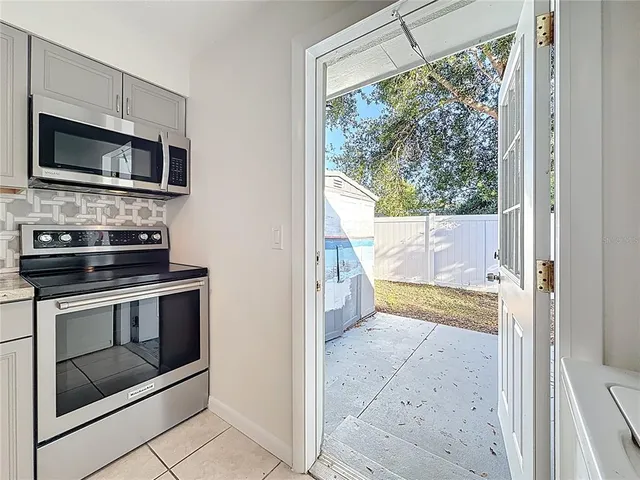 a view of a kitchen in an empty room and a fireplace