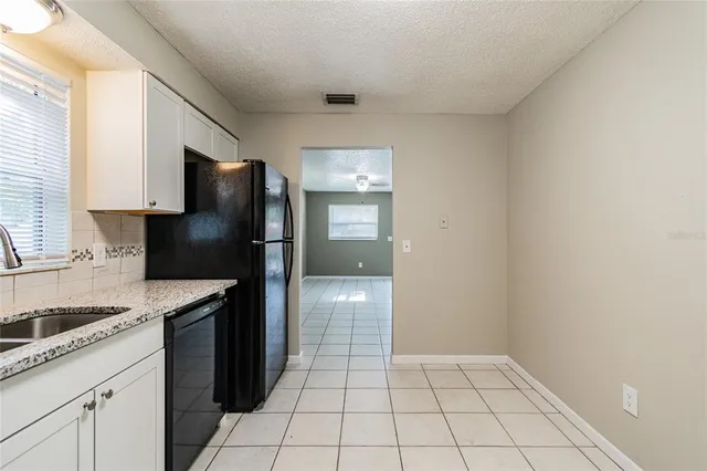 a kitchen with a sink a refrigerator and cabinets