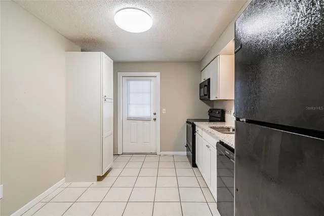 a kitchen with a stove top oven and cabinets