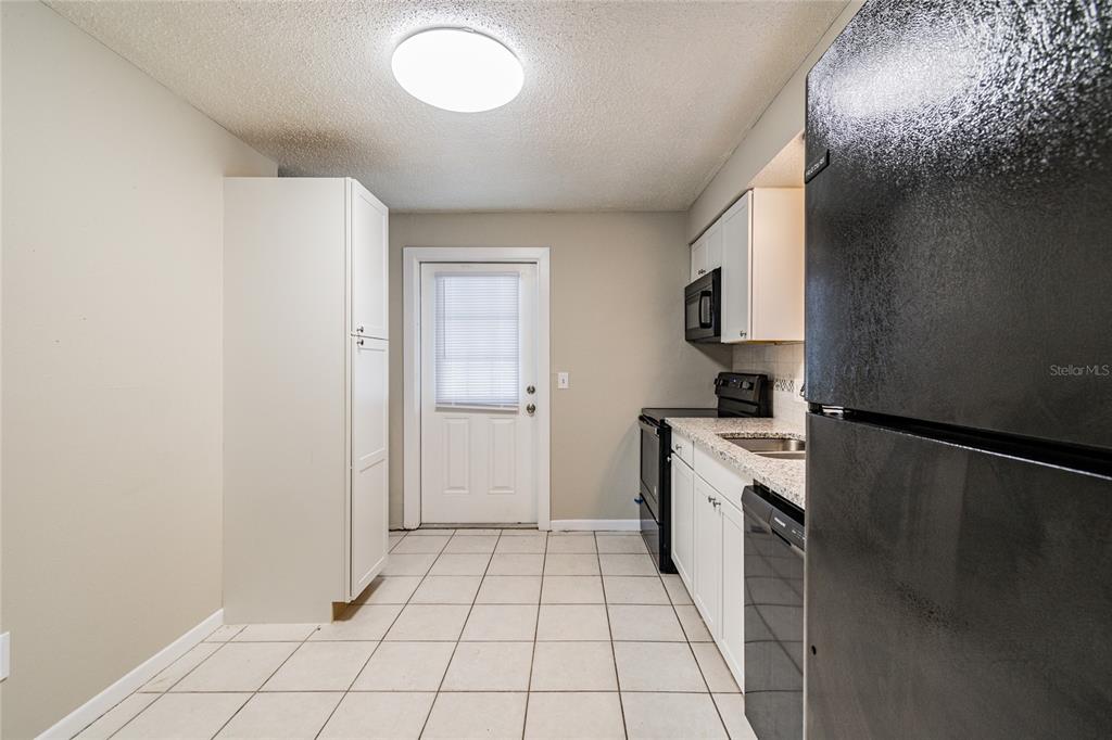 650 Athens Street Dunedin, FL 34698 - Photo 25 of 39 a kitchen with a stove top oven and cabinets