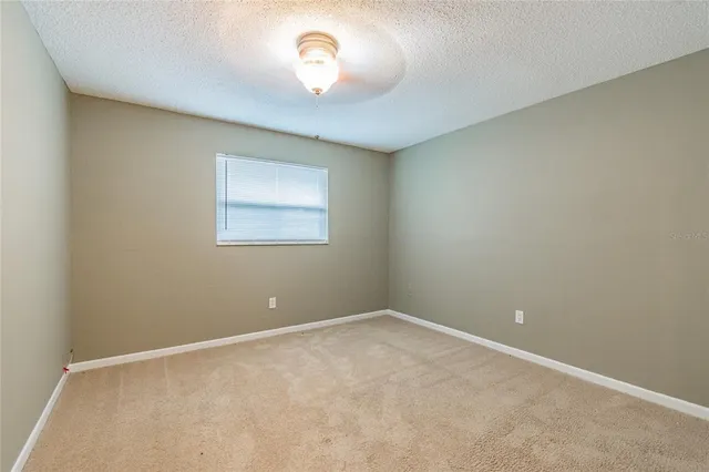 an empty room with a chandelier fan