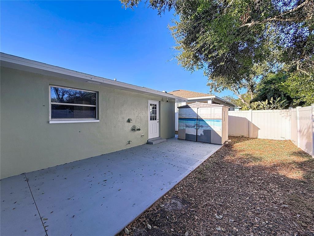 650 Athens Street Dunedin, FL 34698 - Photo 33 of 39 a view of a house with a backyard and a tree