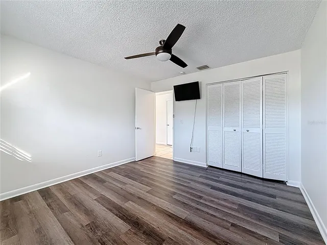 a view of empty room with wooden floor