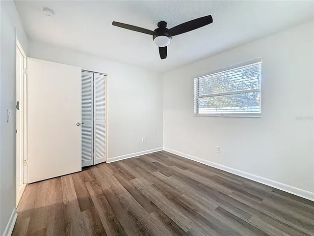a view of empty room with wooden floor