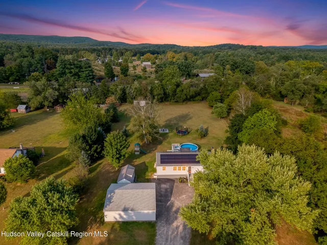 an aerial view of residential houses with outdoor space and lake view