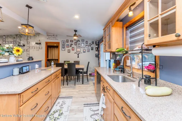 a kitchen with granite countertop a sink a stove a dining table and chairs