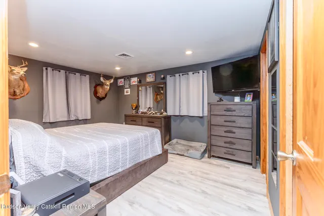 a spacious bedroom with a bed and a flat screen tv