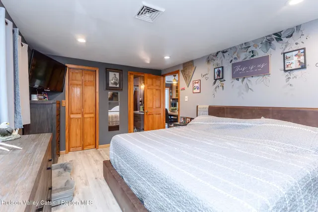 a spacious bedroom with a large bed and a large mirror