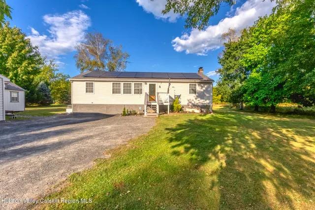 a view of a house with pool and chairs