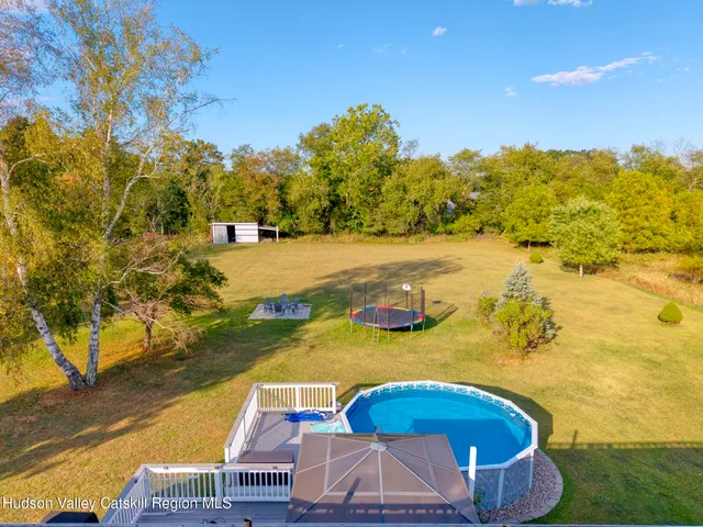 a view of house with wooden deck and furniture