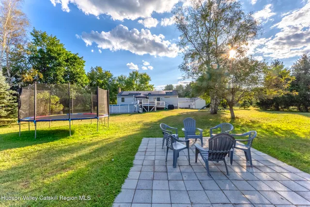 a view of a house with backyard and a tree