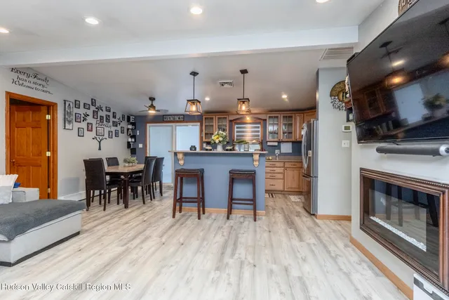 a kitchen with stainless steel appliances granite countertop a stove top oven a sink dishwasher a dining table and chairs with wooden floor