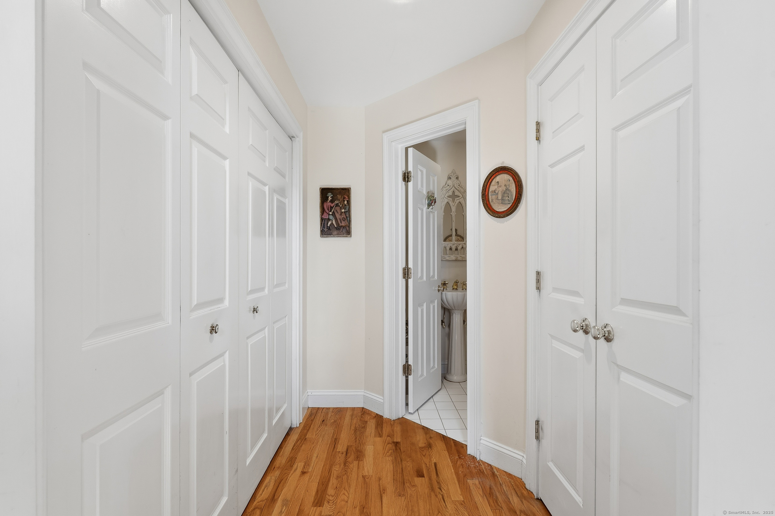 59 Prospect Street, Unit C Ridgefield, CT 06877 - Photo 15 of 38 a view of a hallway with wooden floor and bathroom