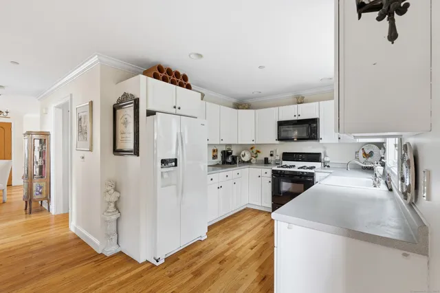 a kitchen with white cabinets and refrigerator