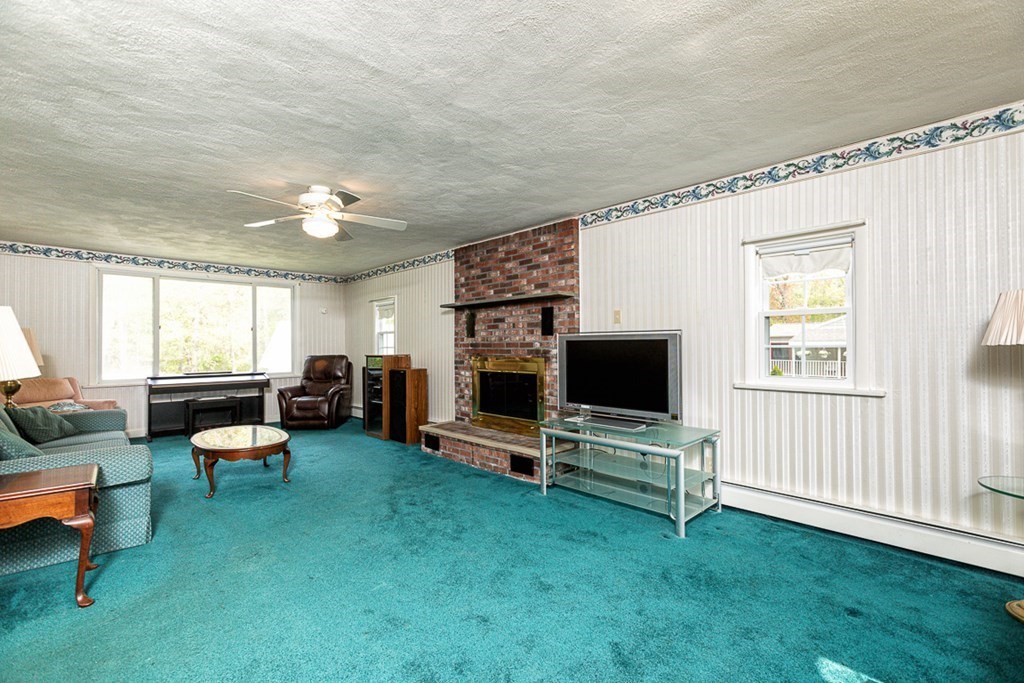113 Newbury Road Rowley, MA 01969 - Photo 11 of 26 a living room with furniture a flat screen tv and a fireplace