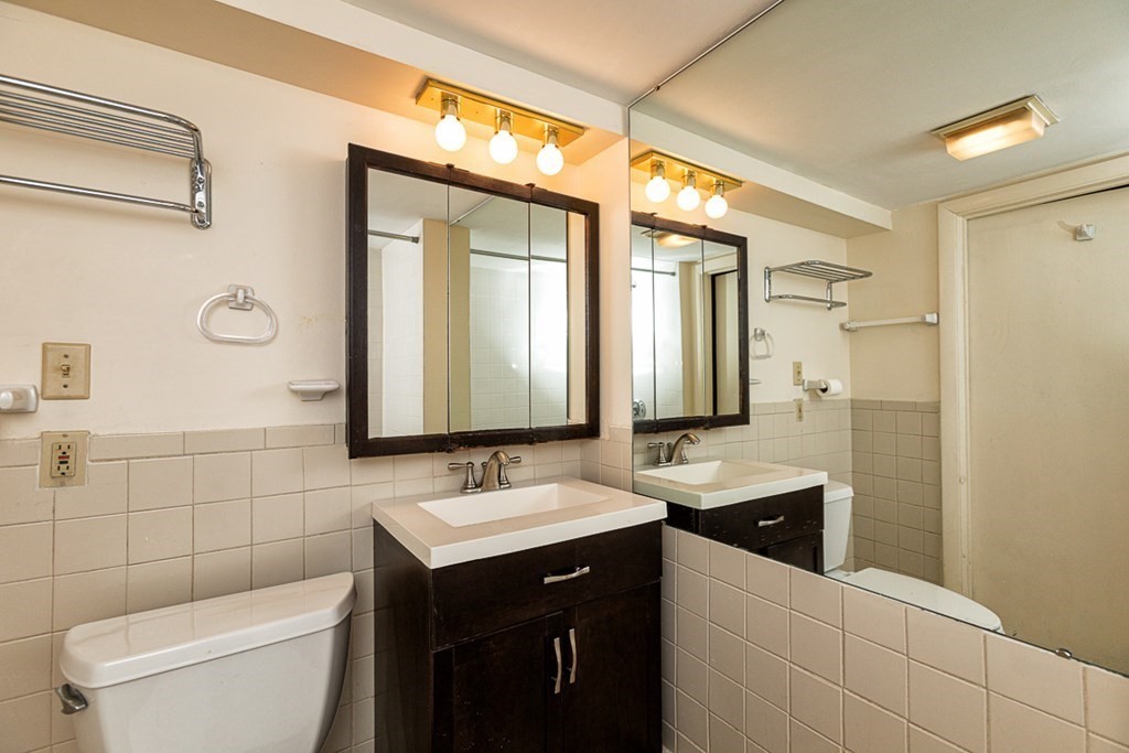 113 Newbury Road Rowley, MA 01969 - Photo 24 of 26 a bathroom with a double vanity sink toilet and a mirror