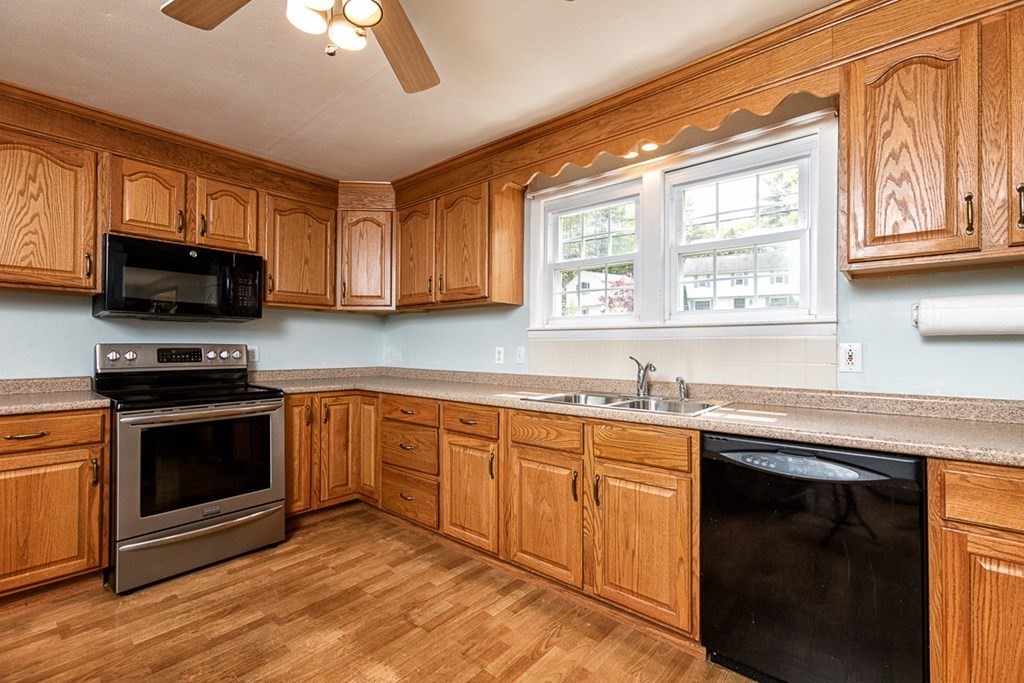113 Newbury Road Rowley, MA 01969 - Photo 8 of 26 a kitchen with stainless steel appliances granite countertop a stove a sink and a microwave