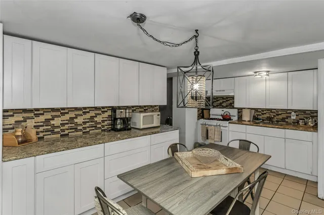 a kitchen with granite countertop white cabinets and stainless steel appliances