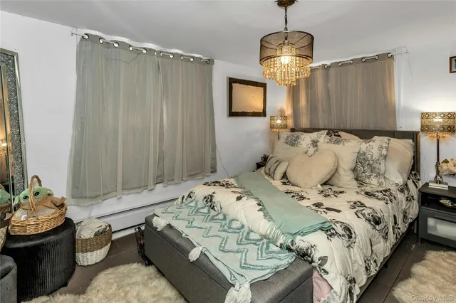 a bed sitting in a bedroom next to a window and a chandelier