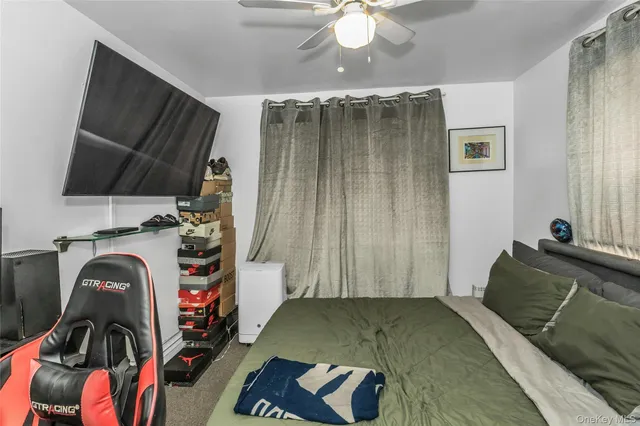 a bedroom with a bed and a flat tv screen on the dresser