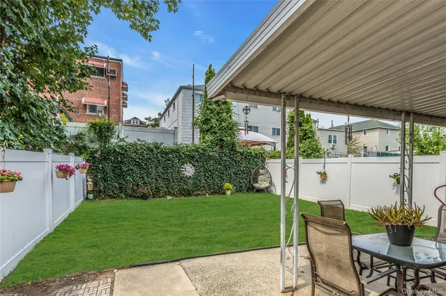 a view of a patio with table and chairs potted plants and palm trees