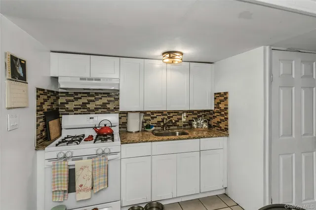a kitchen with white cabinets and a stove