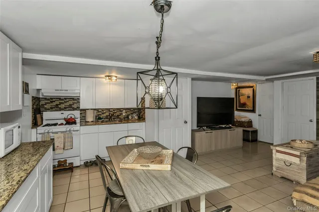 a kitchen with furniture a flat screen tv and kitchen view