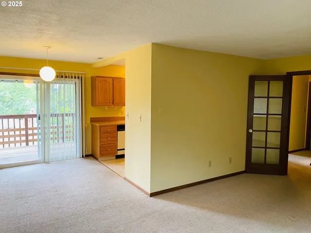 a view of an empty room with a fireplace and a window
