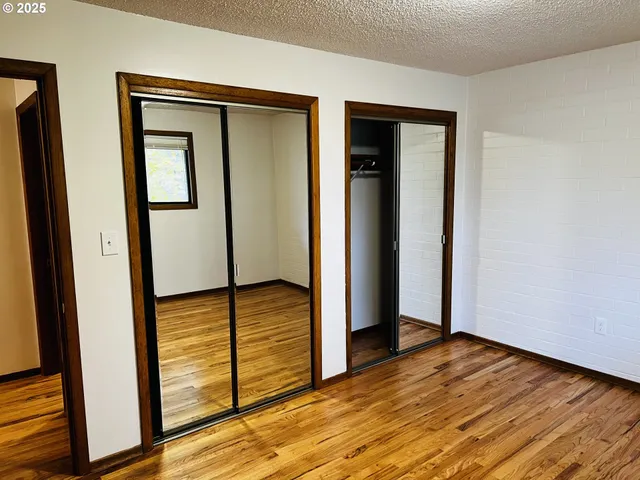 an empty room with wooden floor and entrance