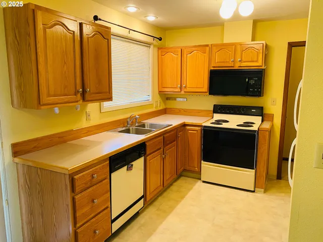 a kitchen with stainless steel appliances a stove a sink and a refrigerator