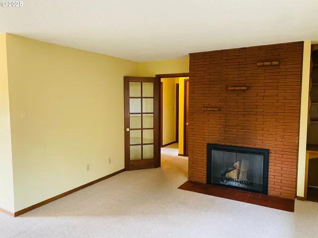 a view of an empty room with a fireplace