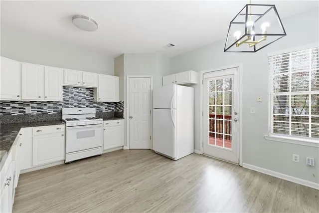 a large white kitchen with stainless steel appliances
