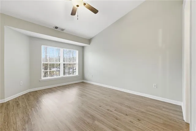 an empty room with wooden floor and closet area