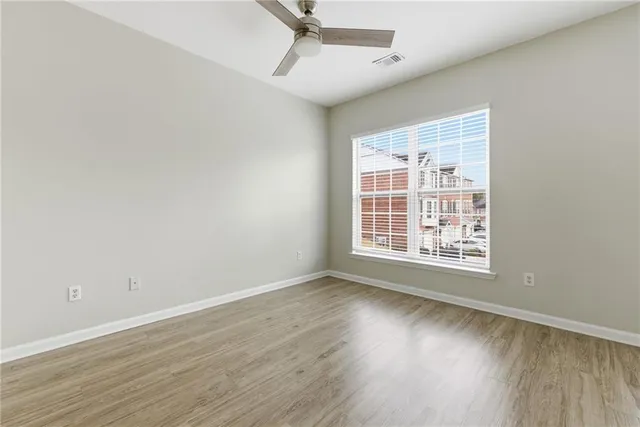a view of empty room with wooden floor and window