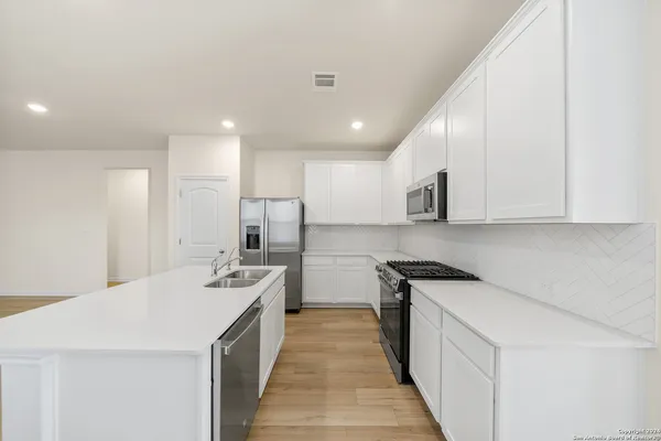 a kitchen with stainless steel appliances a sink stove and refrigerator