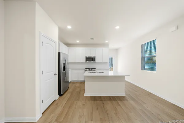 a kitchen with stainless steel appliances a refrigerator and a stove top oven