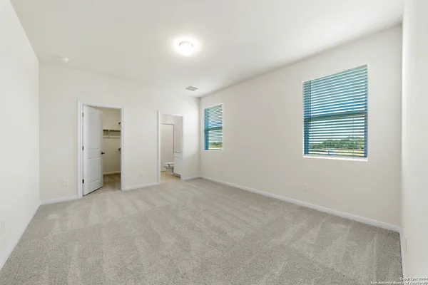 an empty room with a window and a bathroom