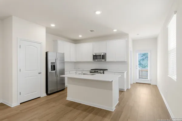 a kitchen with stainless steel appliances a refrigerator and a stove top oven