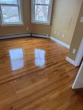 a view of an empty room with wooden floor