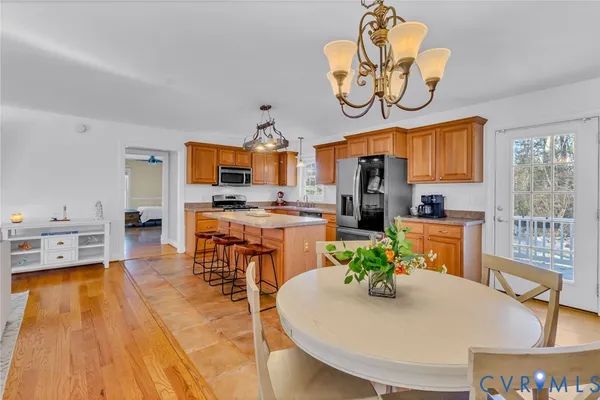 a kitchen with stainless steel appliances granite countertop a stove a sink and a dining table