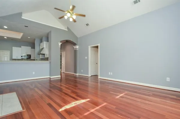 a view of a kitchen with wooden floor and a ceiling fan