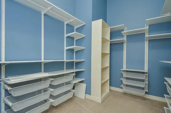 a view of walk in closet with empty racks
