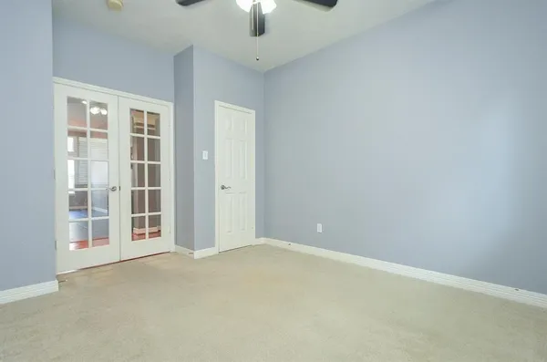 an empty room with chandelier fan