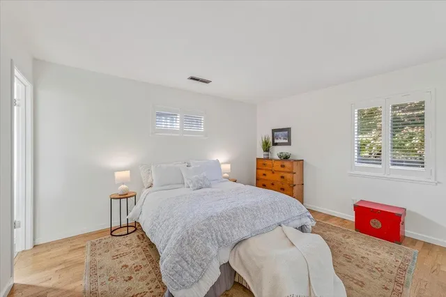 a front view of a house with a yard and trees