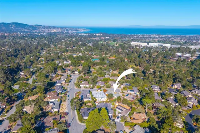 a view of a hallway with wooden floor and a bathroom