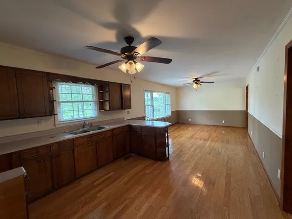 a large kitchen with a wooden floor and cabinets