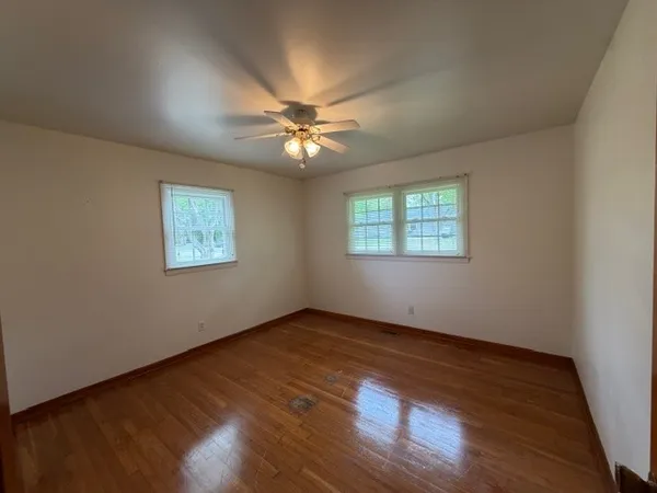 a view of an empty room window and wooden floor